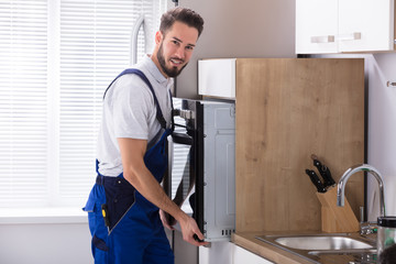 Male Electrician Fixing Oven