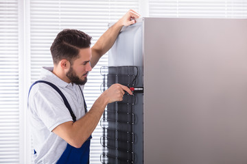 Technician Fixing Refrigerator