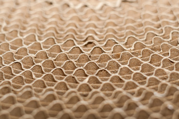 Wavy edges of folded layers of round coil of corrugated cardboard.