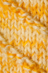 Close-up part of yellow-white knitted crocheted by hand canvas.