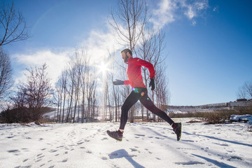 Man running on the snow in a forest