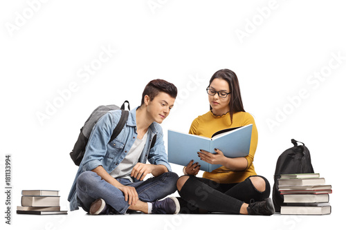 Two Teenage Students Sitting On The Floor And Studying Stock