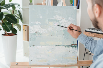 man painting on canvas