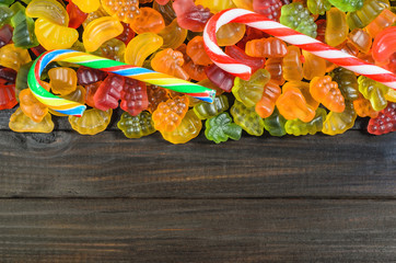 jelly and marmalade candies on a wooden background with free space for text.