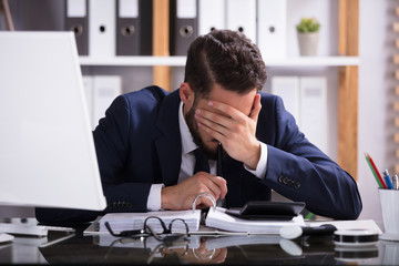 Man Suffering From Headache Working In Office