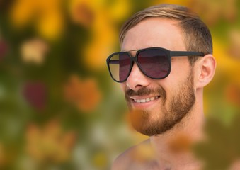 Man's face in forest with leaves and sunglasses