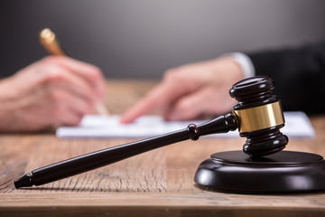 Close-up Of A Gavel On Wooden Desk