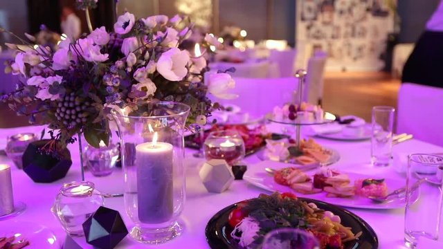 Decorative candles on the dining table, glasses and Christmas candles on the table, white wax candleswith glass candlestick, Candle with Glass Candlestick, restaurant, interior, close-up