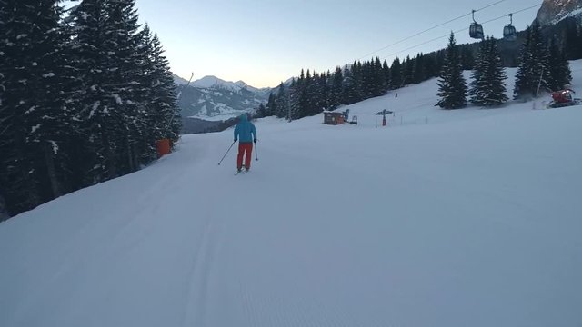 Skier running downhill on piste