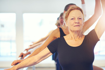 Senior woman performing ballet looking at camera © Flamingo Images