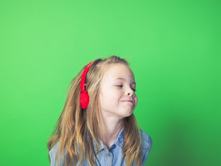 beautiful girl with red headphones in front of green background in the studio