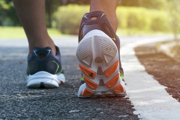 Close up running shoe. / Close up man lifts his heels up from the asphalt runway to run straight ahead.