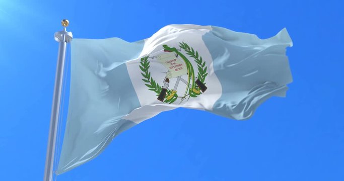 Flag of Guatemala waving at wind with blue sky, loop