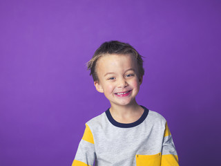 5 year old boy portrait in front of violet background