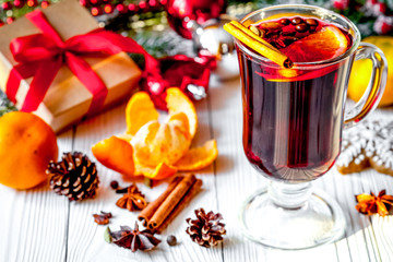 Christmas mulled wine with spices in cup on wooden background