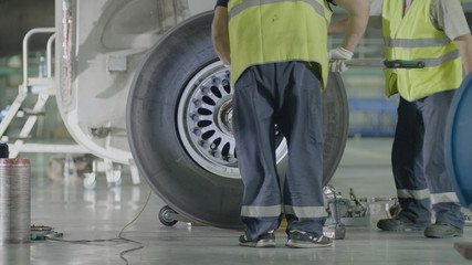 Fototapeta na wymiar Replacement landing gear. Working staff has been working to repair the chassis of a passenger plane