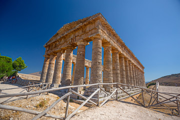 Some tourists visiting ancient Greek temple at Segesta in Sicily, Italy.