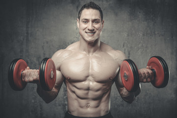 Handsome model young man training arms in gym