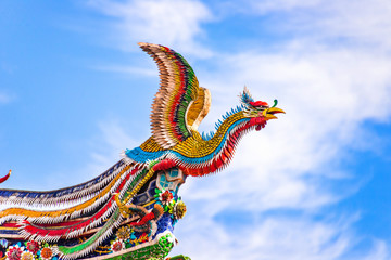 Beautiful Phoenix flying on the decorative tile roof in Chinese temples. Colorful roof detail of...