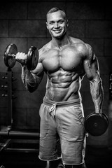 Fototapeta na wymiar Brutal Caucasian bodybuilder working out in gym