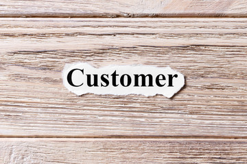 Customer of the word on paper. concept. Words of Customer on a wooden background