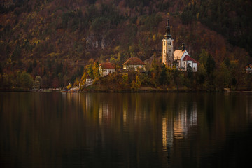 Fototapeta na wymiar Bled, Slovenia - Beautiful autumn at Lake Bled with the famous Pilgrimage Church of the Assumption of Maria and Julian Alps at background