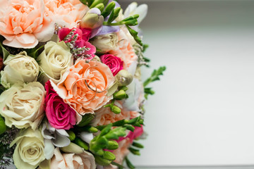 Gold wedding rings on the wedding bouquet of the bride