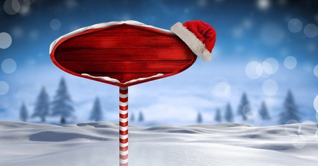 Wooden signpost in Christmas Winter landscape and Santa hat © vectorfusionart