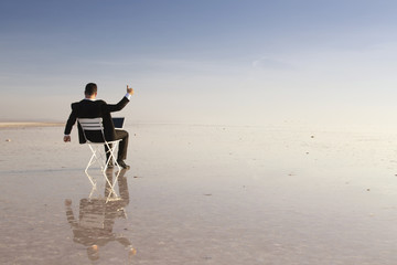 Business man with laptop working on the beach