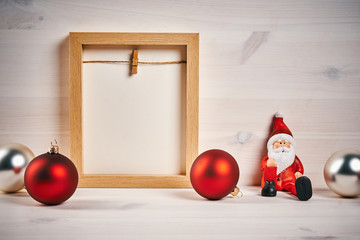 Fototapeta premium Christmas card with decorations on a wooden table with blank frame