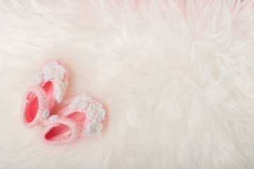 Close up Baby girl knitted shoes on white blanket background.Happy new year greeting card with...