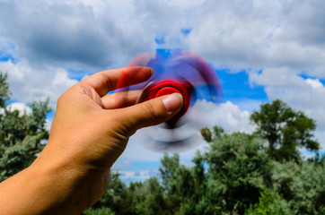 Red fidget spinner rotates in female hand