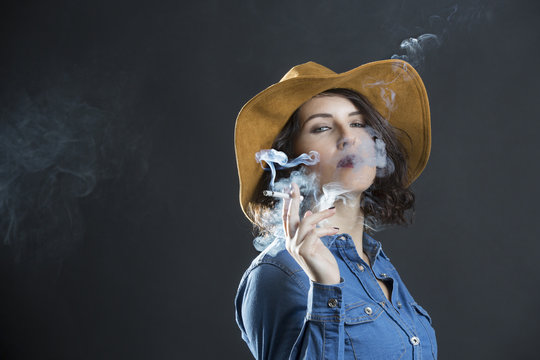 Fumatrice mora si fuma una sigaretta su sfondo scuro