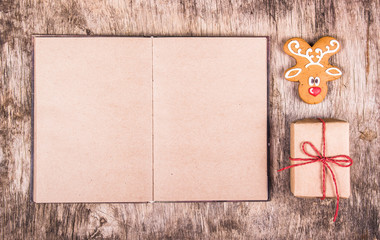 Gingerbread deer, open book and gift. Christmas concept. Copy space