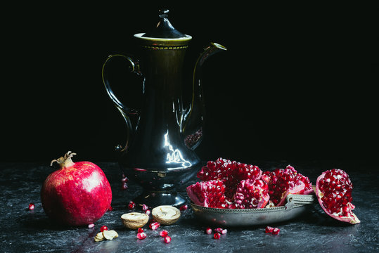Black teapot and pomegranates