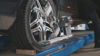 Checking the wheel in garage automobile service, close up