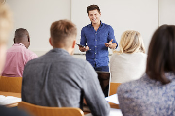 College Tutor With Digital Tablet Teaches Mature Students