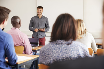 College Tutor With Digital Tablet Teaches Mature Students