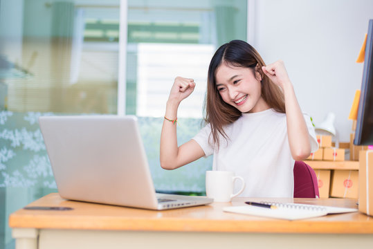 Asian Woman Enjoy Herself While Using Laptops And Internet In Office. Business And Marketing And Part Time Concept. On Line Shopping And Business Success Theme. Happy Mood When Finished Working Job.