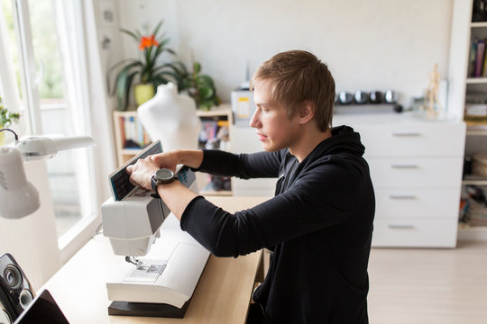 fashion designer with sewing machine at studio