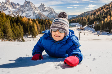 Fototapeta na wymiar smiling baby lying on the snow