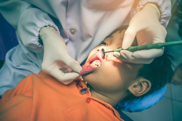 Dentist checked and curing teeth a child patient in the dental office.