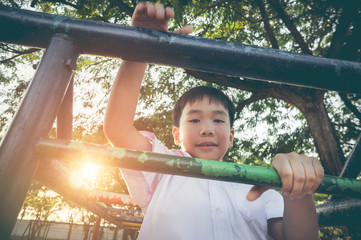 Happy asian child having fun at children playground. Vintage tone.