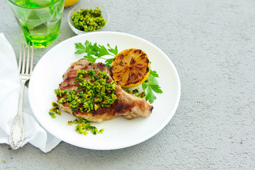 Pork cutlet on a bone with gremolat sauce.