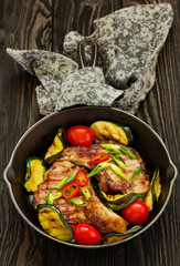 Pork cutlet on a bone with baked vegetables.
