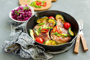 Pork cutlet on a bone with baked vegetables.