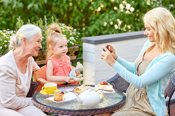 woman photographing her family at cafe