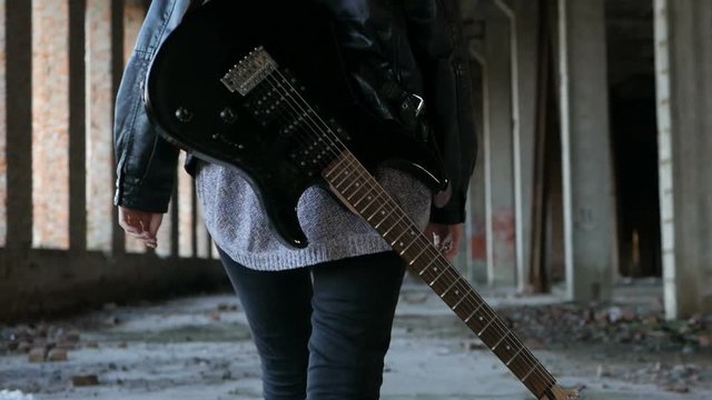 woman with guitar walking
