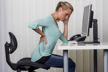 woman with backache in the office - Powered by Adobe