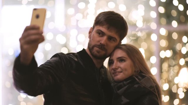 Young happy couple take selfie photos at camera on smart mobile cell phone 